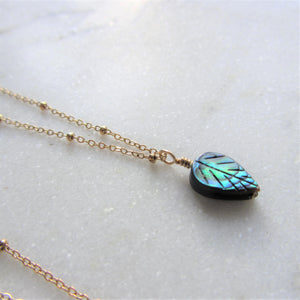 The Abalone Leaf necklace's pendant hangs on a gold stainless steel chain.
