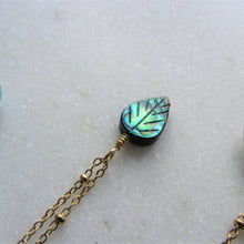 Load image into Gallery viewer, The Abalone Leaf necklace's pendant hangs on a gold stainless steel chain.
