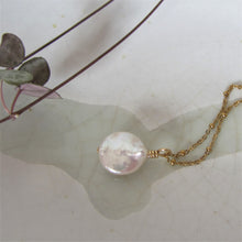 Load image into Gallery viewer, A white round flat keshi pearl hangs on a gold stainless steel chain.
