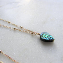 Load image into Gallery viewer, The Abalone Leaf necklace&#39;s pendant hangs on a gold stainless steel chain.