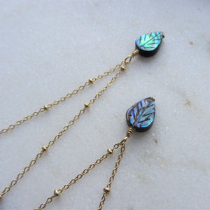 The Abalone Leaf necklace's pendant hangs on a gold stainless steel chain.