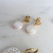 Load image into Gallery viewer, White round flat keshi pearls hang on drop shaped gold earring settings.